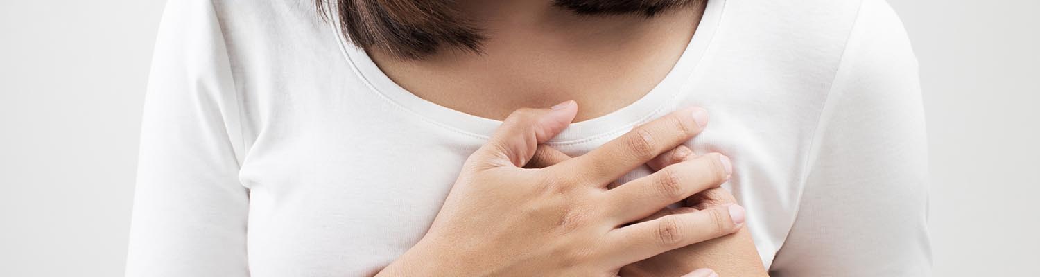 Closeup of woman holding her hands to her heart